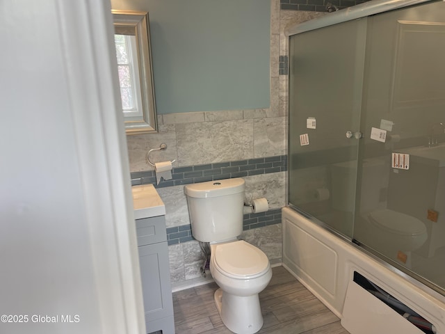 full bath with vanity, toilet, a wainscoted wall, tile walls, and wood finished floors