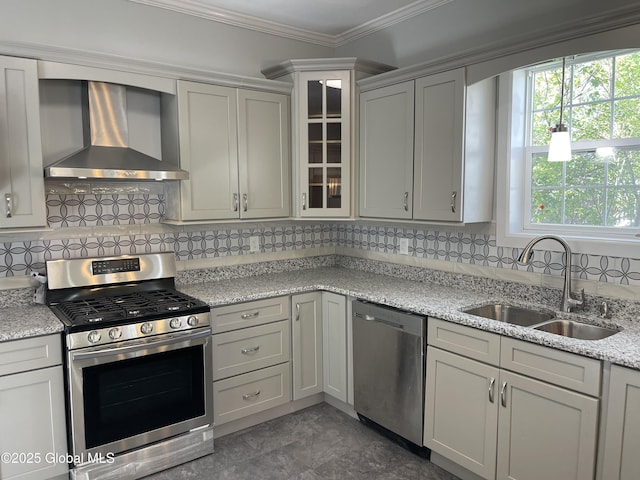 kitchen featuring wall chimney range hood, a sink, stainless steel appliances, decorative backsplash, and ornamental molding