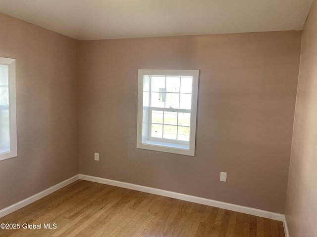 empty room with baseboards and light wood-style flooring