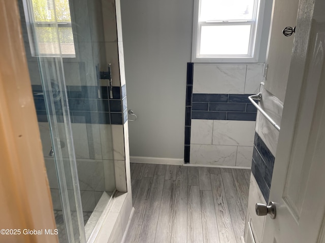 full bathroom featuring a shower stall and wood finished floors
