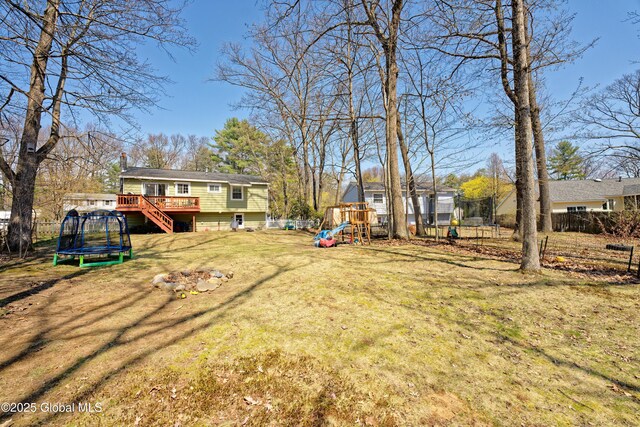 view of yard with a playground, a trampoline, and a deck