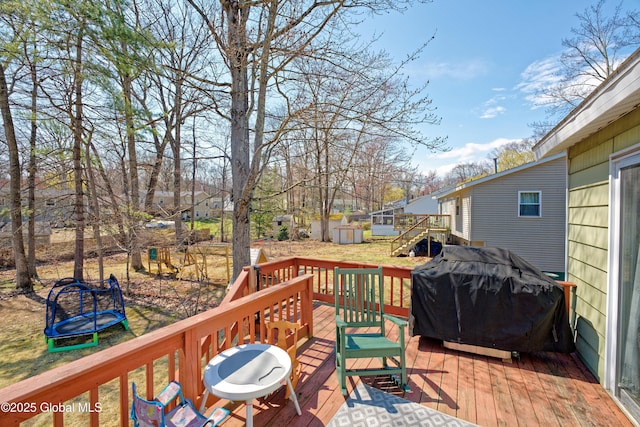 wooden terrace featuring an outdoor structure and grilling area