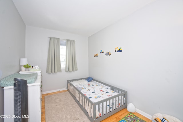 bedroom with baseboards and wood finished floors