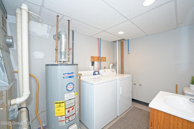 laundry area with laundry area, a sink, gas water heater, separate washer and dryer, and recessed lighting