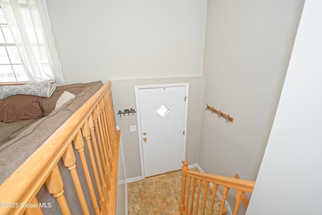 entrance foyer featuring baseboards and stone finish floor