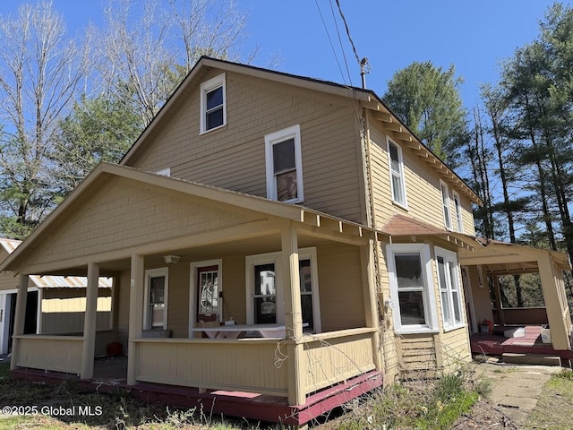 rear view of house featuring covered porch