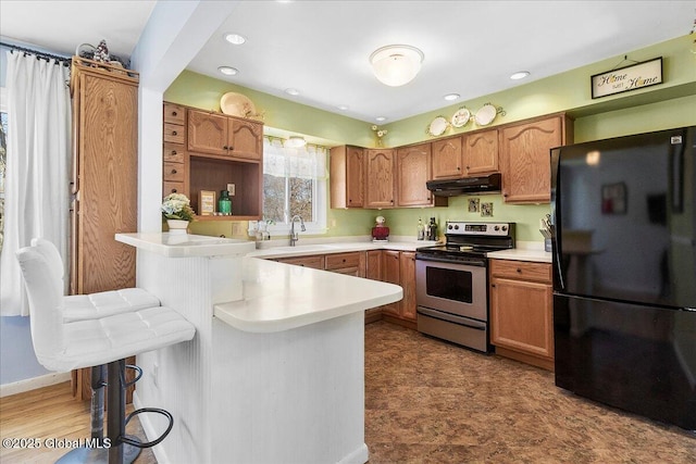 67 Fairlawn Dr, Colonie, NY 12110 - kitchen with freestanding refrigerator, stainless steel range with electric cooktop, under cabinet range hood, a peninsula, and a breakfast bar