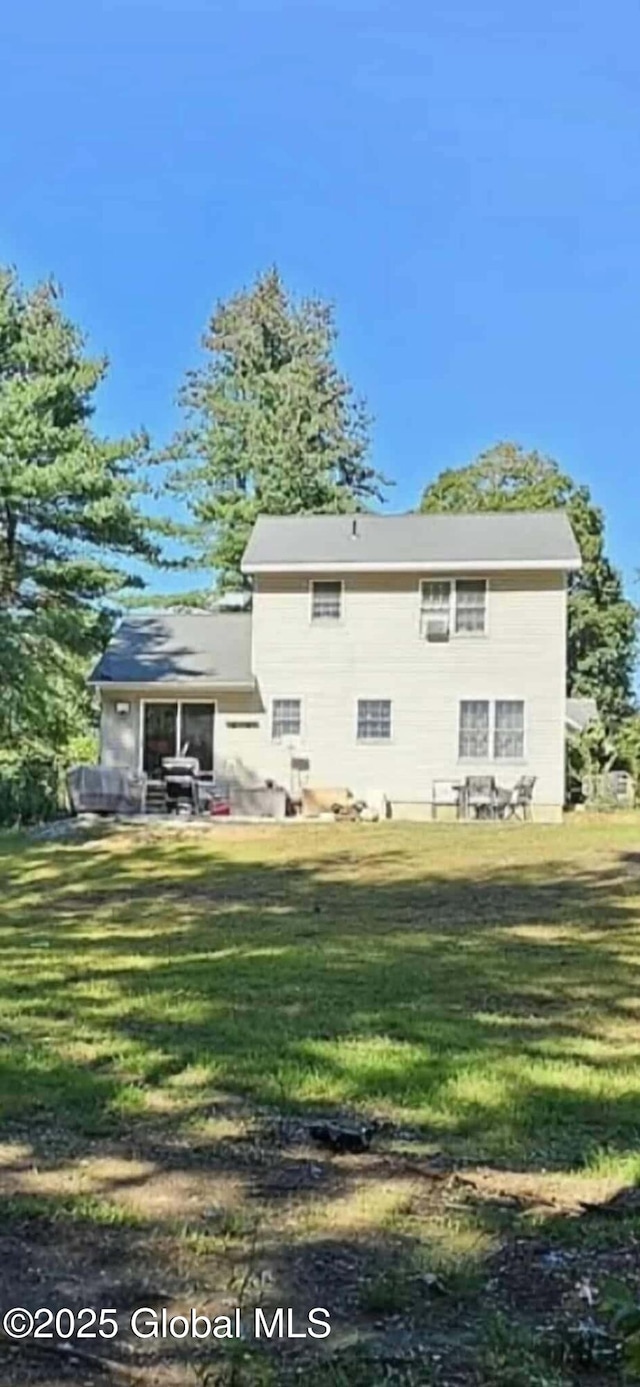 rear view of property featuring a yard