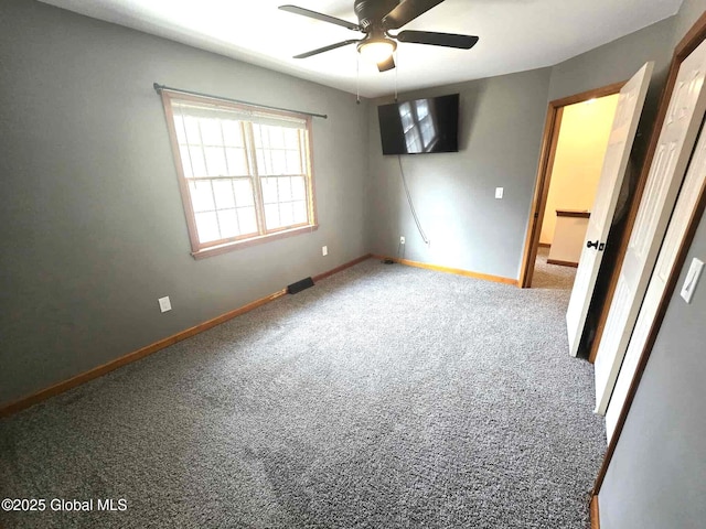 unfurnished bedroom with carpet flooring, a ceiling fan, and baseboards