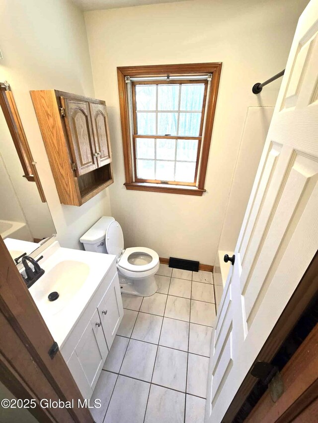 bathroom with walk in shower, tile patterned flooring, vanity, toilet, and baseboards