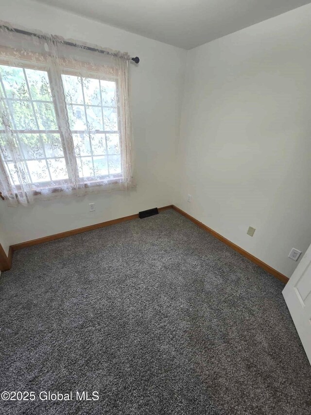 unfurnished room featuring baseboards and carpet