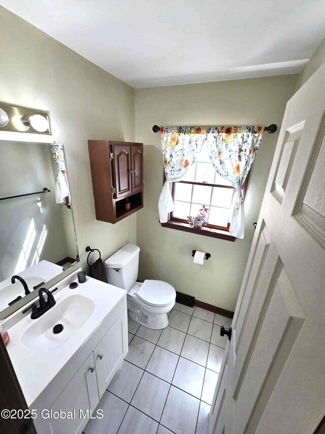 bathroom with toilet, tile patterned floors, and vanity