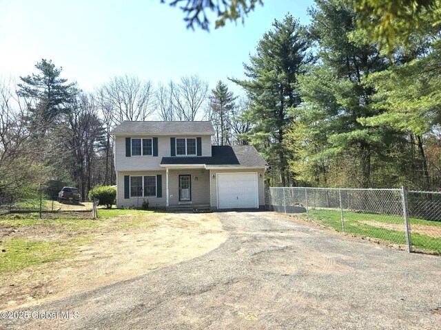 view of front of house featuring fence, driveway, and a garage