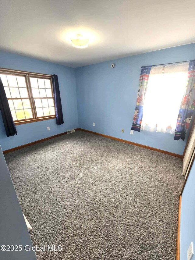 empty room with baseboards, carpet, and visible vents