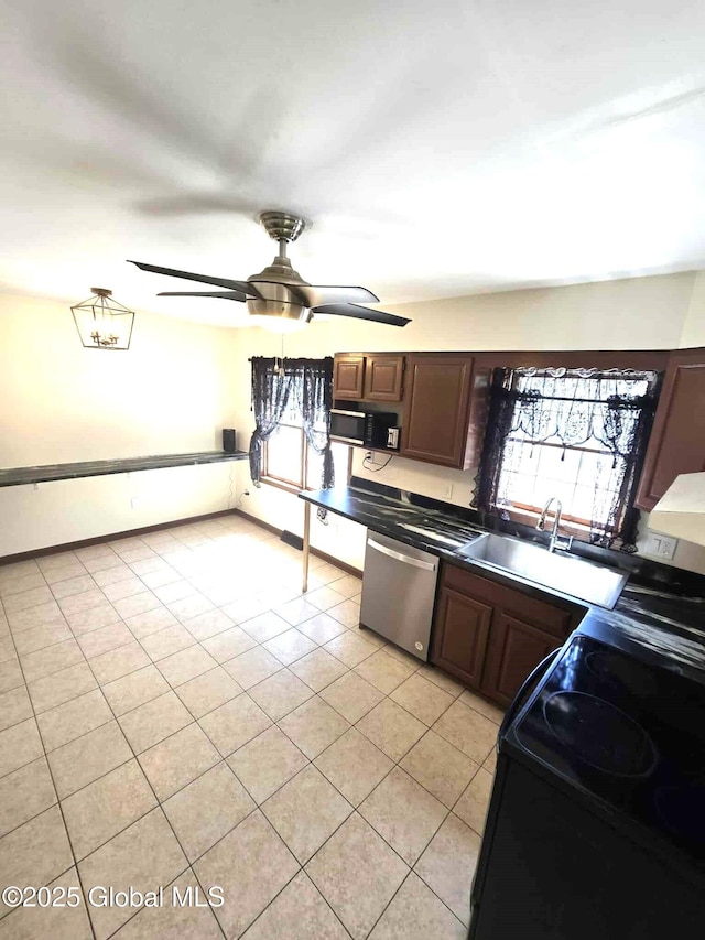 kitchen featuring light tile patterned floors, plenty of natural light, black appliances, and a sink