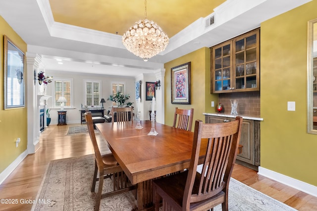 73 Railroad Pl Unit 403-404, Saratoga Springs, Inside, NY 12866 - dining area with light wood finished floors, a chandelier, baseboards, a tray ceiling, and ornamental molding