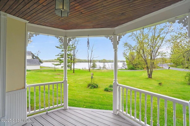 deck with a water view and a yard