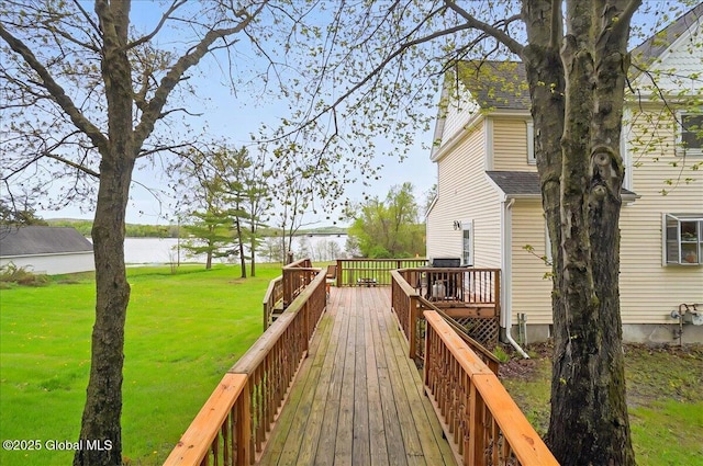 wooden deck with a water view and a yard