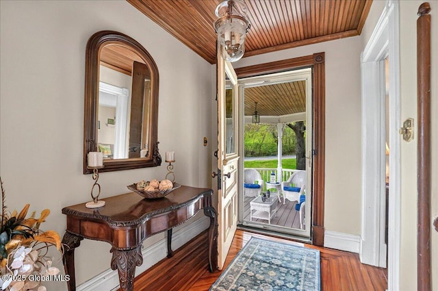 entryway with wood ceiling, crown molding, arched walkways, wood finished floors, and baseboards