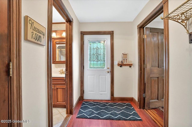 doorway with light wood-style flooring and baseboards