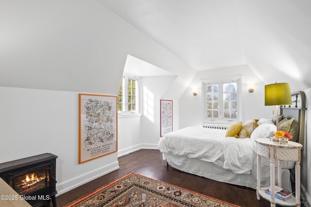 bedroom featuring baseboards, vaulted ceiling, and wood finished floors