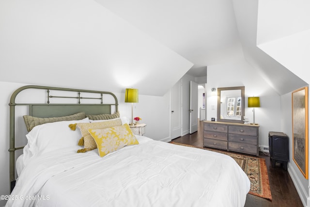 bedroom featuring baseboards, vaulted ceiling, and wood finished floors