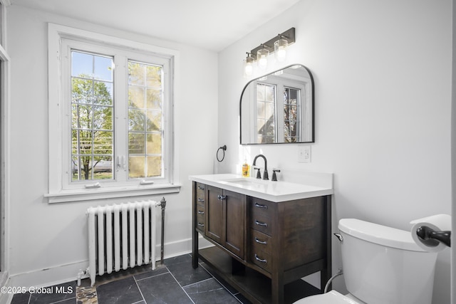 bathroom featuring toilet, baseboards, radiator heating unit, and vanity