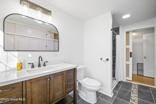 full bath featuring vanity, baseboards, a stall shower, and toilet