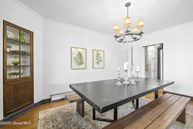 dining area featuring crown molding, a notable chandelier, baseboard heating, and wood finished floors