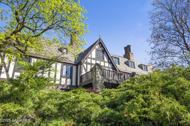 rear view of house featuring a chimney and a wooden deck