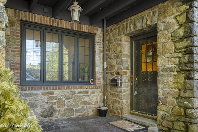 doorway to property featuring stone siding