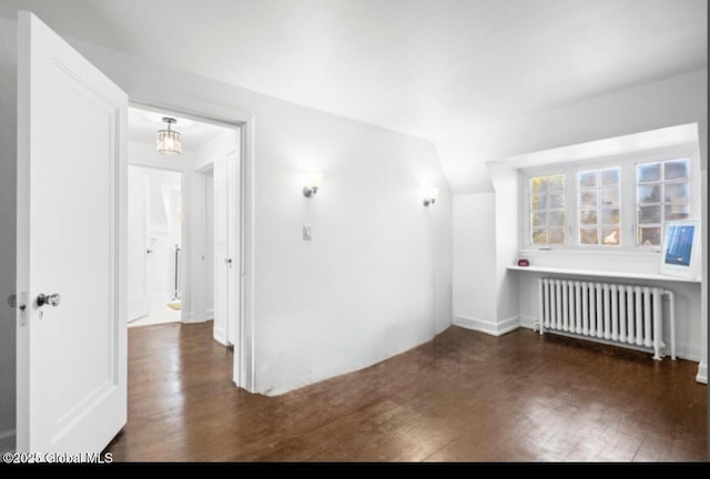 unfurnished room featuring radiator, lofted ceiling, and wood finished floors