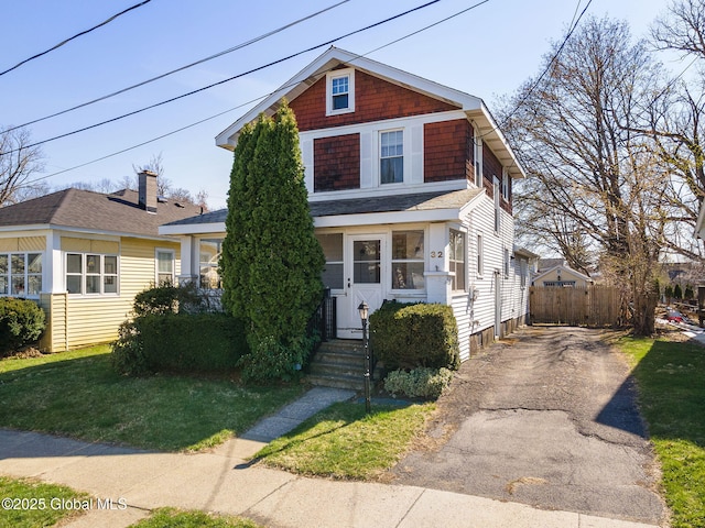 american foursquare style home featuring fence and driveway