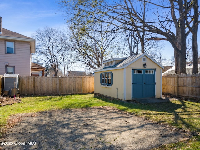 garage featuring fence and a storage shed