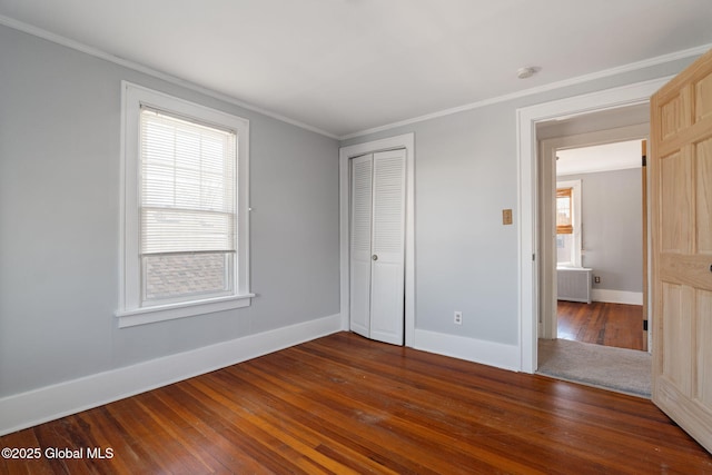 unfurnished bedroom featuring dark wood-style floors, ornamental molding, and multiple windows