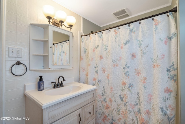 full bath featuring crown molding, vanity, tile walls, and visible vents