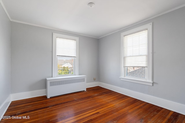 empty room with baseboards, ornamental molding, radiator heating unit, and hardwood / wood-style floors
