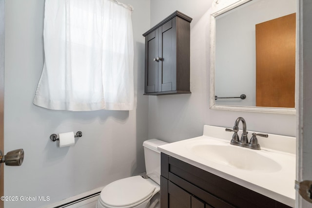 half bath with vanity, a baseboard heating unit, and toilet