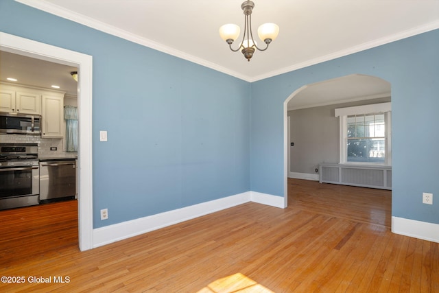 unfurnished room featuring an inviting chandelier, crown molding, radiator heating unit, arched walkways, and light wood-style flooring