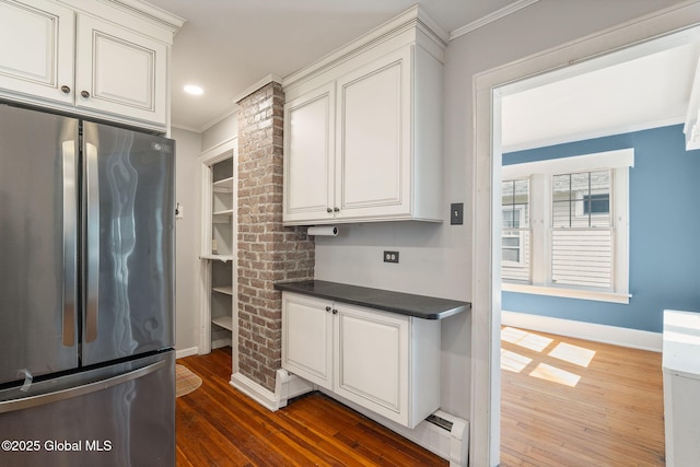 kitchen featuring crown molding, dark countertops, freestanding refrigerator, and dark wood-style floors