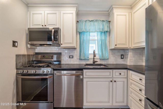 kitchen with a sink, appliances with stainless steel finishes, tasteful backsplash, and dark countertops