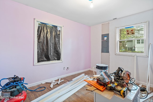 interior space with electric panel, light wood-style flooring, and baseboards