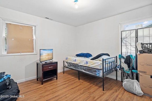 bedroom featuring light wood-style flooring, baseboards, and visible vents