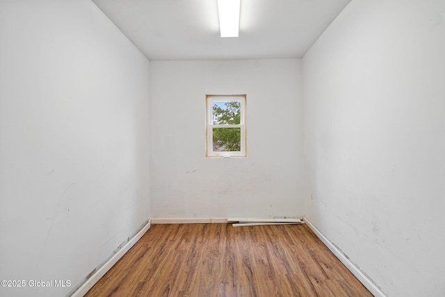 spare room featuring wood finished floors and baseboards