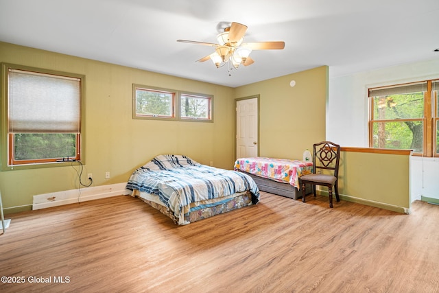 bedroom with ceiling fan, baseboards, and wood finished floors