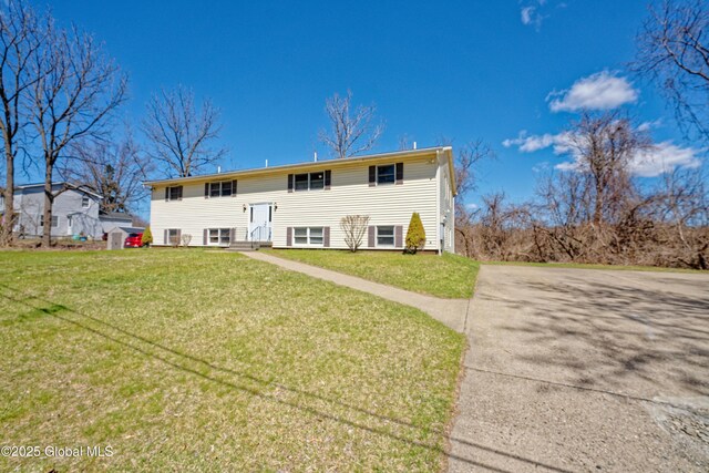 back of property featuring a lawn and entry steps