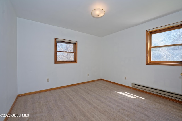 spare room with baseboards, wood finished floors, and baseboard heating