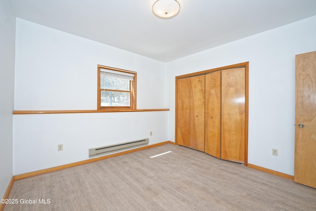unfurnished bedroom with baseboards, wood finished floors, and baseboard heating