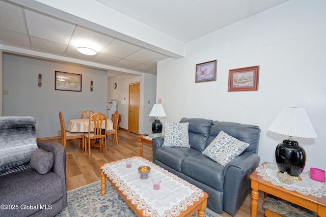 living area with wood finished floors and a paneled ceiling