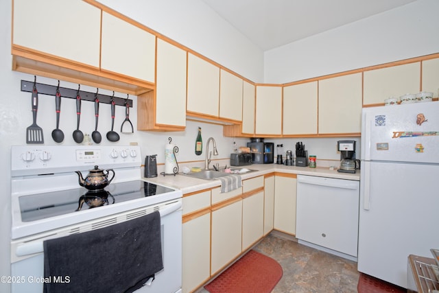 kitchen with a sink, light countertops, white appliances, and stone finish flooring